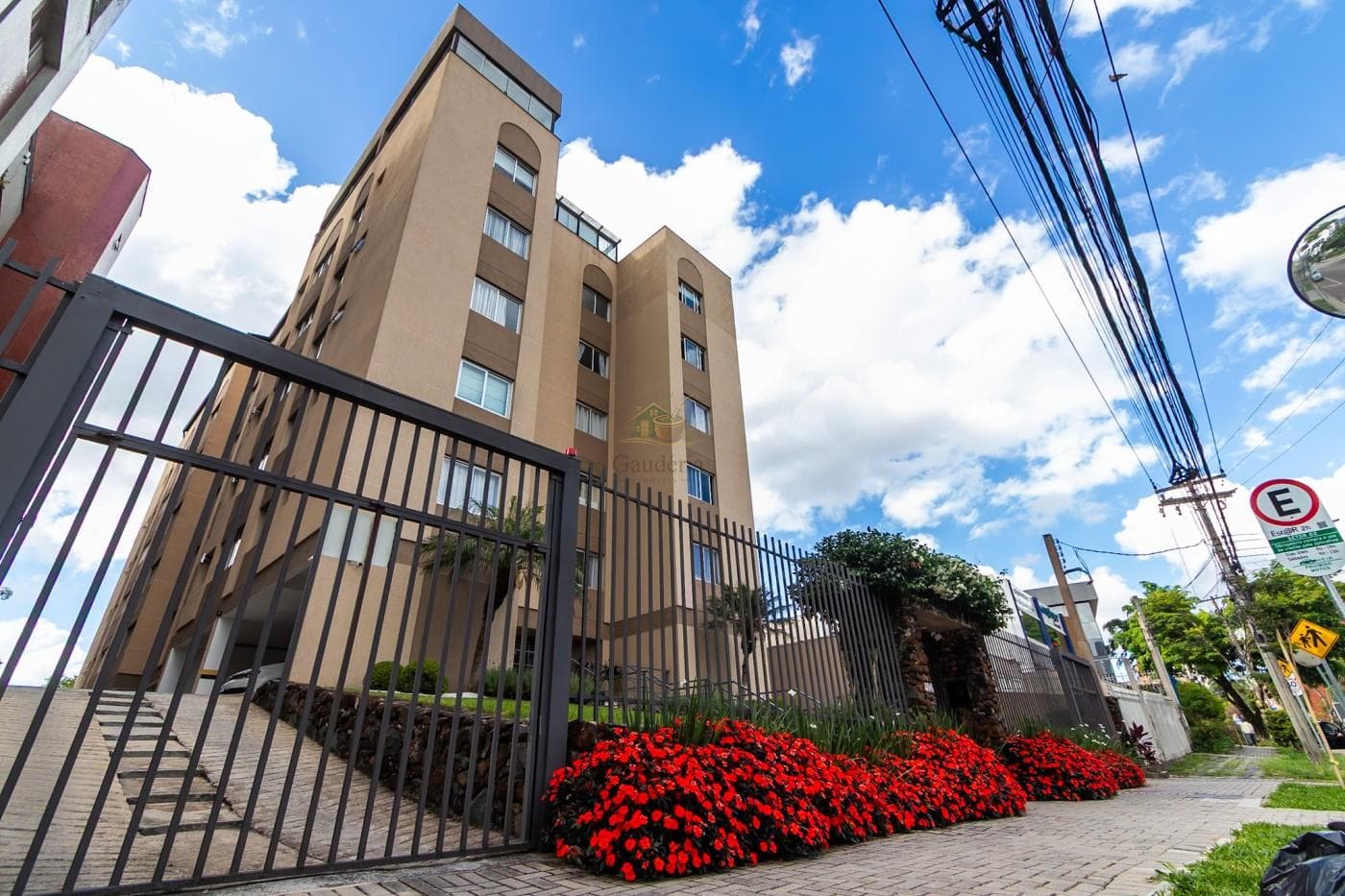 Fachada do edifício residencial de múltiplos andares com portão de entrada.