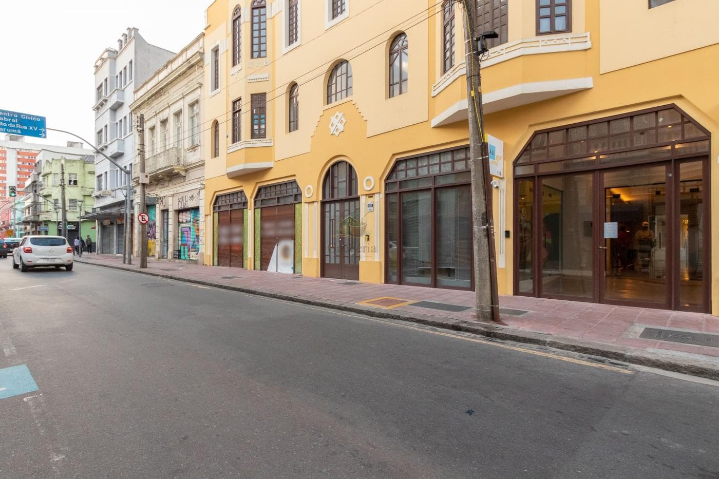 Vista externa da fachada do edifício na rua, mostrando o térreo e a calçada.